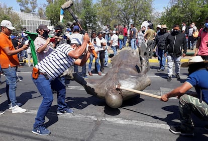 Miembros del Consejo Indígena destruyen la estatua de Fray Antonio de San Miguel en Morelia, el lunes.
