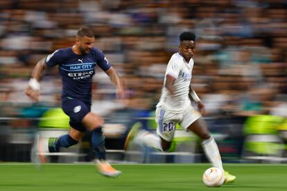 El delantero Real Madrid Vinicius Junior (d) escapa de Kyle Walker, del Manchester City, durante el partido de semifinales de la Liga de Campeones.