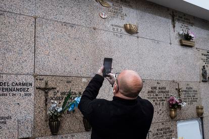 El hijo del exboxeador Manuel Álvarez hace una foto al número del nicho donde han enterrado el cadáver de su padre para recordar la ubicación, en el Cementerio Sur de Madrid.