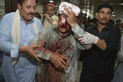 Voluntarios ayudan a una de las personas heridas este martes en Peshawar (Pakistán).