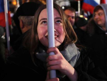 Una ciudadana sostiene una bandera rusa, durante las celebraciones de la jornada electoral, este domingo en Moscú.