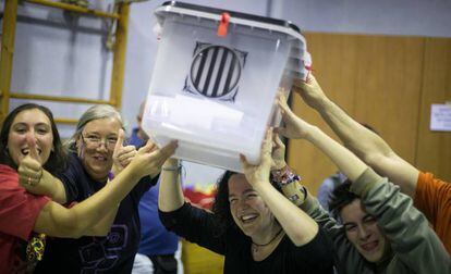 Un grupo de personas sostiene una urna en un colegio de Barcelona durante el referéndum del 1 de octubre de 2017.