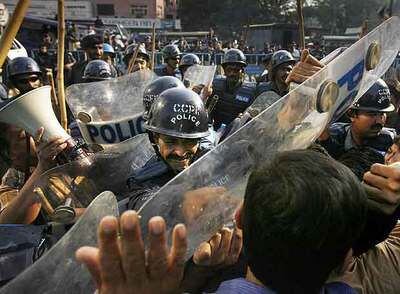 Policías cargan contra una concentración de periodistas críticos con el Gobierno, en Karachi.