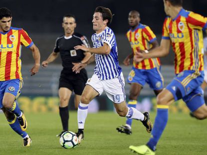 Odriozola rodeado de jugadores del Valencia, en un partido de Liga.