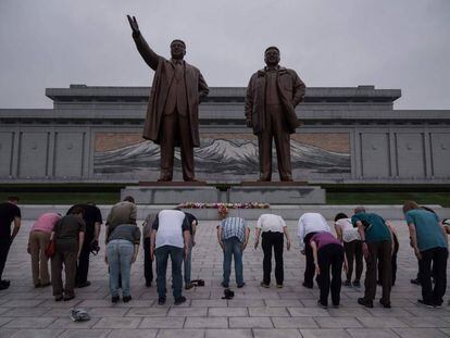 Un grupo de turistas frente a una estatua de Kim Il-Sung (izquierda) y Kim Jong-Il (derecha), en Pyongyang este domingo.