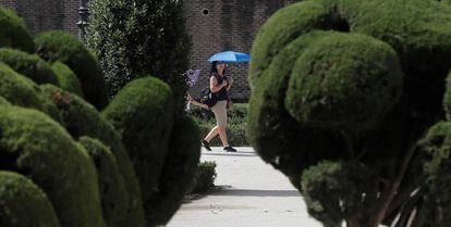 Una turista se protege del sol en El Retiro.