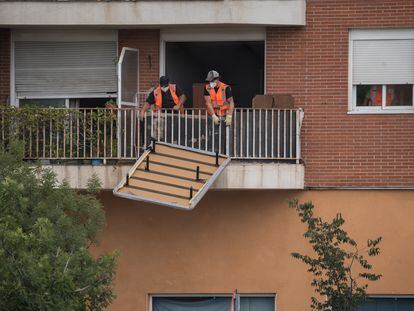 Un trabajador saca un canapé por el balcón durante el desalojo de 62 familiasen Alcobendas, Madrid (España).