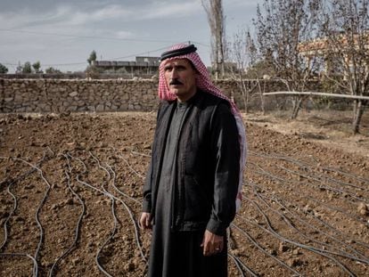 Un agricultor iraquí junto a su terreno, seco, al lado de un canal de irrigación.