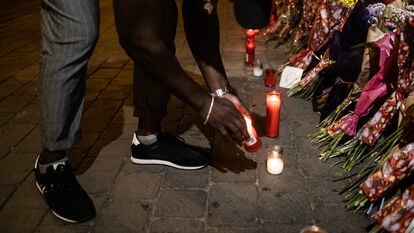 Buba enciende una vela junto a las flores en homenaje a Conchi en la plaza de Tirso de Molina.