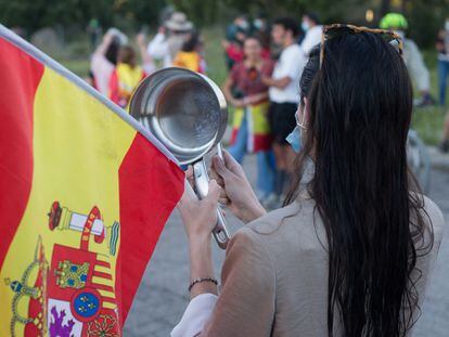 Una mujer golpea cacerolas en señal de protesta cerca de la vivienda del vicepresidente del Gobierno de España, Pablo Iglesias, y la ministra de Igualdad, Irene Montero.