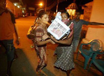 Una mujer salva sus pertenencias en Colombo después de que el Gobierno de Sri Lanka alertase a la población.