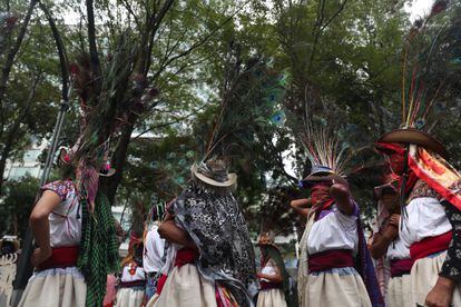 Mujeres con vestimenta tradicional, pasamontañas y sombreros adornados con plumas de pavorreal, fotografiadas durante la marcha.