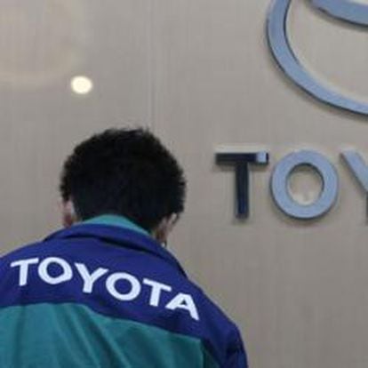 Un trabajador pasa por delante del logo de Toyota en la central de la empresa en Tokio.