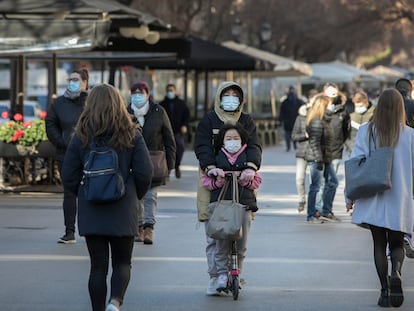 Una mujer conduce un patinete por una zona peatonal de Barcelona y llevando a una niña, dos cuestiones prohibidas con la nueva norma de circulación.