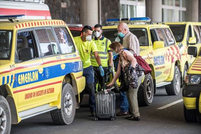 Dos viajeros reciben asistencia de los servicios de emergencias tras desembarcar en Lanzarote del vuelo procedente de Madrid en el que uno de los ocupantes ha dado positivo en covid-19.