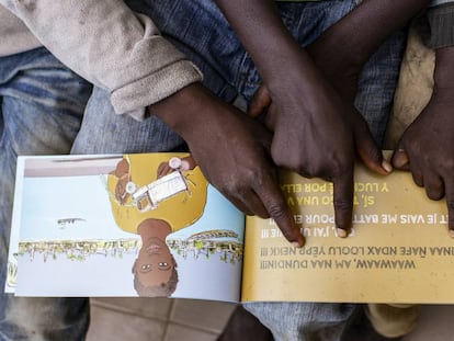 Niños acogidos en el centro La Maison de la Gare, miran el libro 'Solo la vida'.
