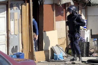 Un policía antidisturbios, ante una de las viviendas.