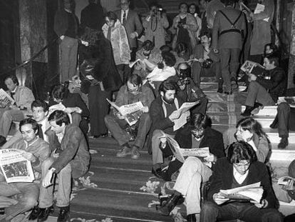 Varios periodistas leen EL PA&Iacute;S en la noche del golpe de Estado fallido del 23-F, en las escaleras del hotel Palace. 