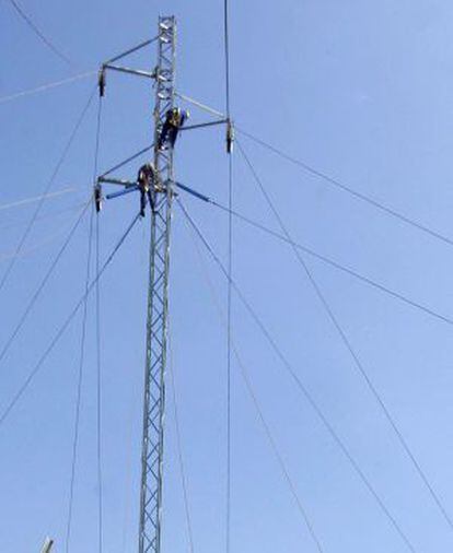 Los operarios de una compa&ntilde;&iacute;a el&eacute;ctrica reparan una torre de alta tensi&oacute;n.