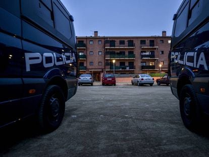 Dos furgonetas de la Policía Nacional custodiando un edificio.