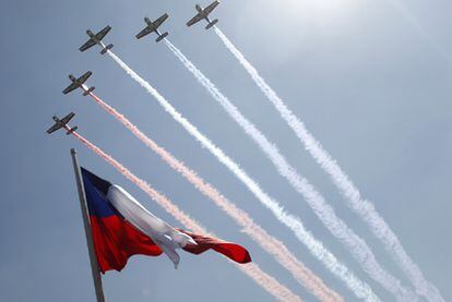 La bandera chilena ondea ayer mientras un grupo de aviones sobrevuela La Moneda en el Bicentenario.