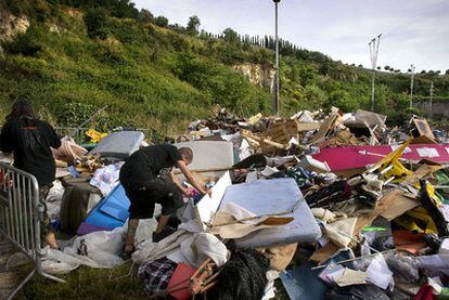 Dos jóvenes rebuscan entre los objetos que se sacaron de la plaza de Catalunya, depositados en una cantera abandonada de Montjuïc.