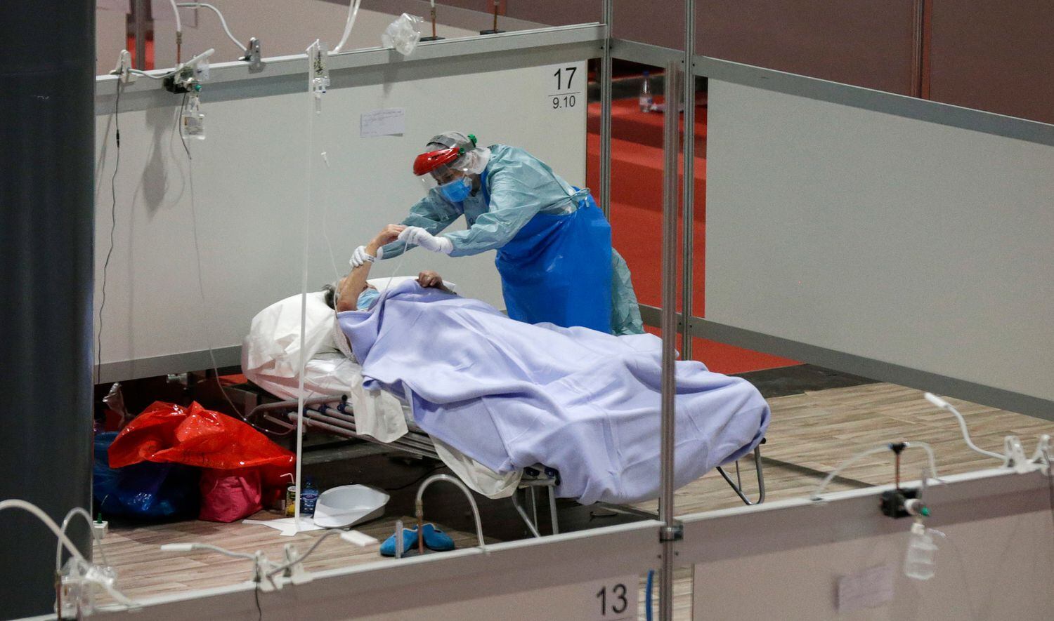 Un profesional sanitario atiende a un paciente en el hospital de Ifema, en Madrid.