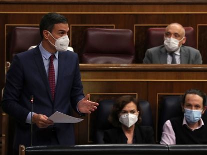Pedro Sánchez habla en el Congreso con Carmen Calvo y Pablo Iglesias a su lado.