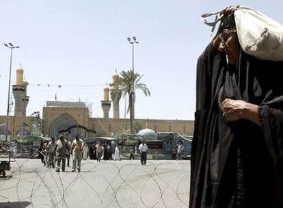 Una mujer iraquí pasa por delante de una mezquita en el distrito chií de Kadhimiya, en Bagdad.