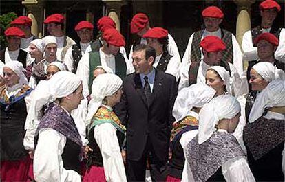 El <i>lehendakari,</i> Juan José Ibarretxe, rodeado de un grupo de <i>dantzaris</i>, ayer en Vitoria.