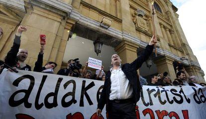 Juan Carlos Izagirre blande la vara de mando ante un cartel que dice: "El cambio ha llegado a San Sebastián".