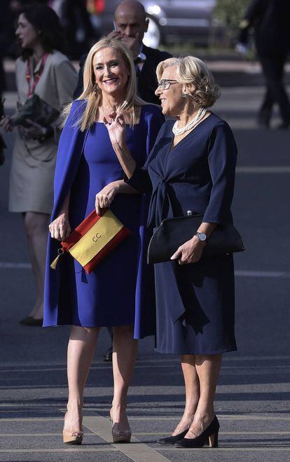 La presidenta de la Comunidad de Madrid, Cristina Cifuentes, con un bolso de la bandera de España, conversa con la alcaldesa de Madrid, Manuela Carmena.