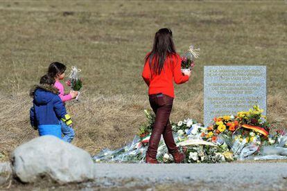 Una mujer y dos niñas llevan flores al memorial erigido por las víctimas del avión de Germanwings en Le Vernet, este viernes.