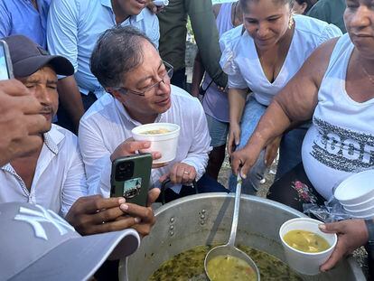 El presidente de Colombia, Gustavo Petro,  recibe sancocho de en una olla comunitaria.