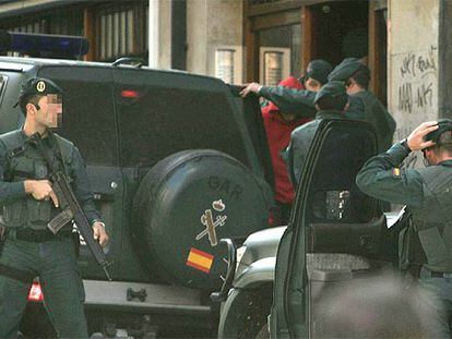 Agentes de la Guardia Civil trasladan a uno de los detenidos el miércoles con boletines de ETA.