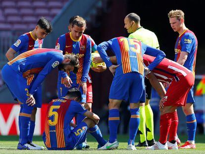 El árbitro Mateu Lahoz y varios jugadores se interesan por el estado del jugador del FC Barcelona Sergio Busquets, conmocionado tras un golpe.