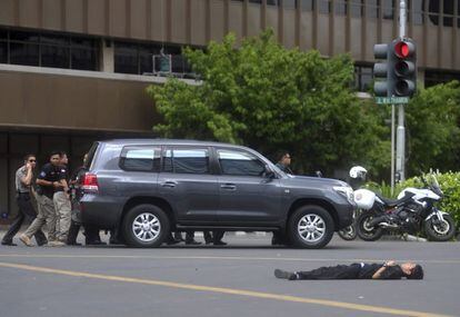 El cuerpo sin vida de un hombre permanece tirado en la carretera tras la explosión.