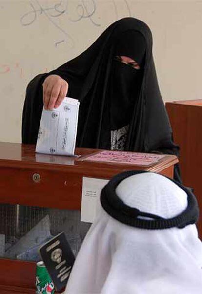 Una mujer deposita su voto en el colegio electoral de Salwa (Kuwait).