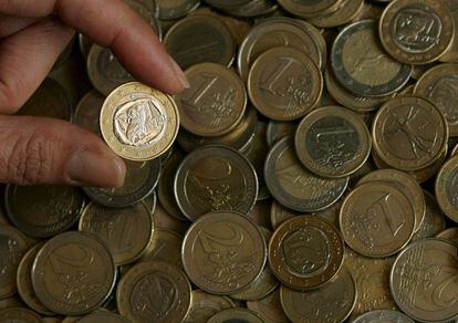 Una persona ense&ntilde;a una moneda de euro de Grecia entre otras monedas de la zona euro en Atenas, Grecia. EFE/Archivo