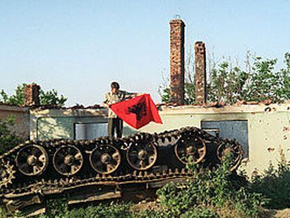 En la aldea de Matejce, un albanés  agita una bandera albanesa sobre los restos de un blindado macedonio destruido en la guerra.