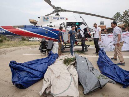 Policías nepalís y miembros de los servicios de rescate, con cuatro de los cadáveres rescatados, en Katmandú.