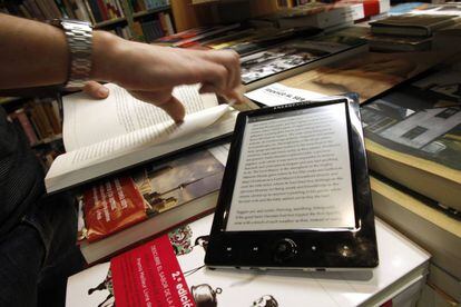 Un libro electrónico comparte espacio con otros títulos en formato papel en una librería.