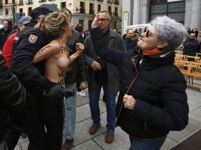 Una dona clava una bufetada a una activista de Femen mentre és detinguda per la Policia, el 18 de novembre del 2018. Tres integrants de Femen amb el lema "Feixisme legal, vergonya nacional" escrit al pit interrompen un acte franquista a la plaça d'Oriente de Madrid.