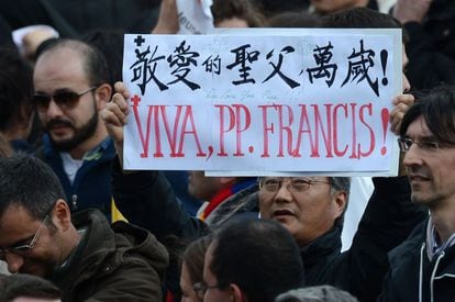 Un hombre sujeta un cartel escrito en varios idiomas durante la misa inaugural del papa Francisco.