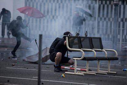 Un manifestante se proteje de los botes lacrimógenos disparados por la policía en el distrito de Sha Tin de Hong Kong.