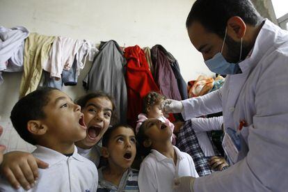 Niños desplazados sirios hacen cola para recibir la vacuna contra la poliomielitis en el campo de refugiados en la ciudad libanesa de Sidón en 2013