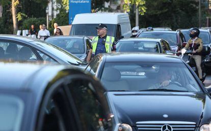 Un policía municipal gestiona el tráfico en Arturo Soria, este lunes.