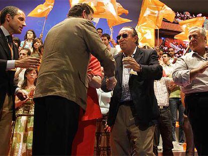 Mariano Rajoy (de espaldas) saluda a Carlos Fabra, presidente de la Diputación de Castellón, en presencia del presidente de la Comunidad Valenciana, Francisco Camps.