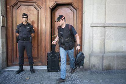 Agentes de la Guardia Civil salen de la sede de Catdem y F&ograve;rum Barcelona tras registrarlas el pasado agosto.