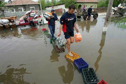 Un hombre rumano camina sobre cajas de plástico por una calle inundada de la localidad de Spantov.